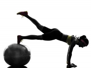 one woman exercising fitness workout plank position on fitness ball in silhouette on white background